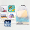 A collection of reusable drawstring storage bags in various colors and a pack of rolled fabric items are displayed on a white