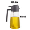 A gray glass oil sprayer bottle with a black handle and spout.