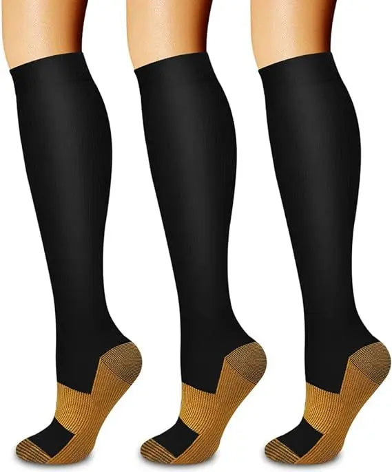 A set of three black women's compression socks with gold accents shown on legs.