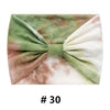 Bandeau en coton tie-dye plié avec des tons de vert, marron et blanc.