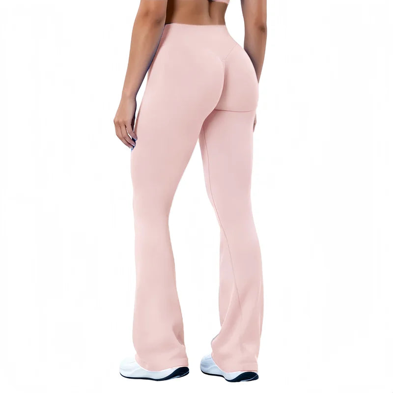 A model wearing light pink seamless flared yoga leggings and white athletic shoes.