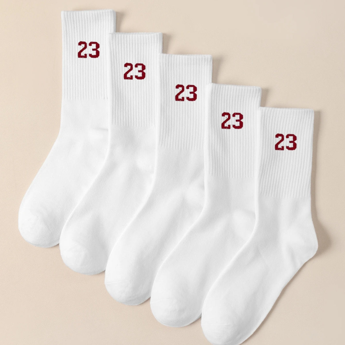 A stack of white men's classic crew socks with red numbering indicating size 23.