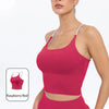 A model wearing a bright raspberry red summer strappy yoga sports bra top.