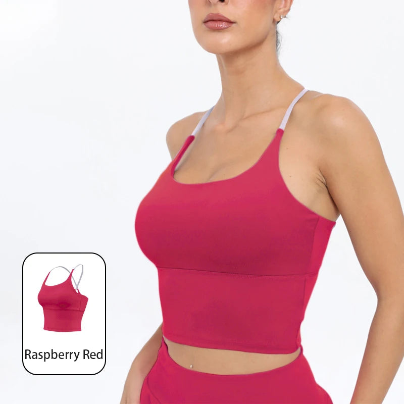 A model wearing a bright raspberry red summer strappy yoga sports bra top.