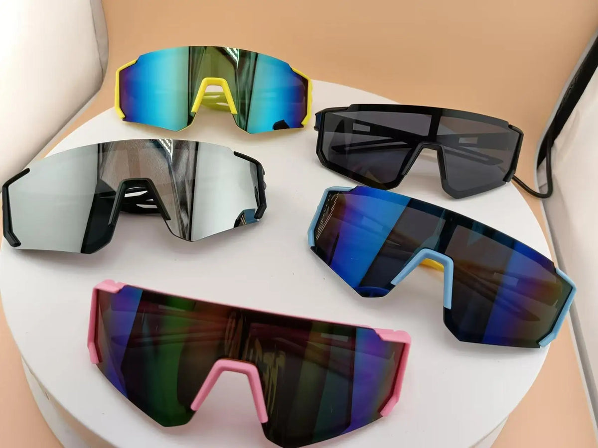 A collection of colorful sports sunglasses for kids, including blue, yellow, and black frames.