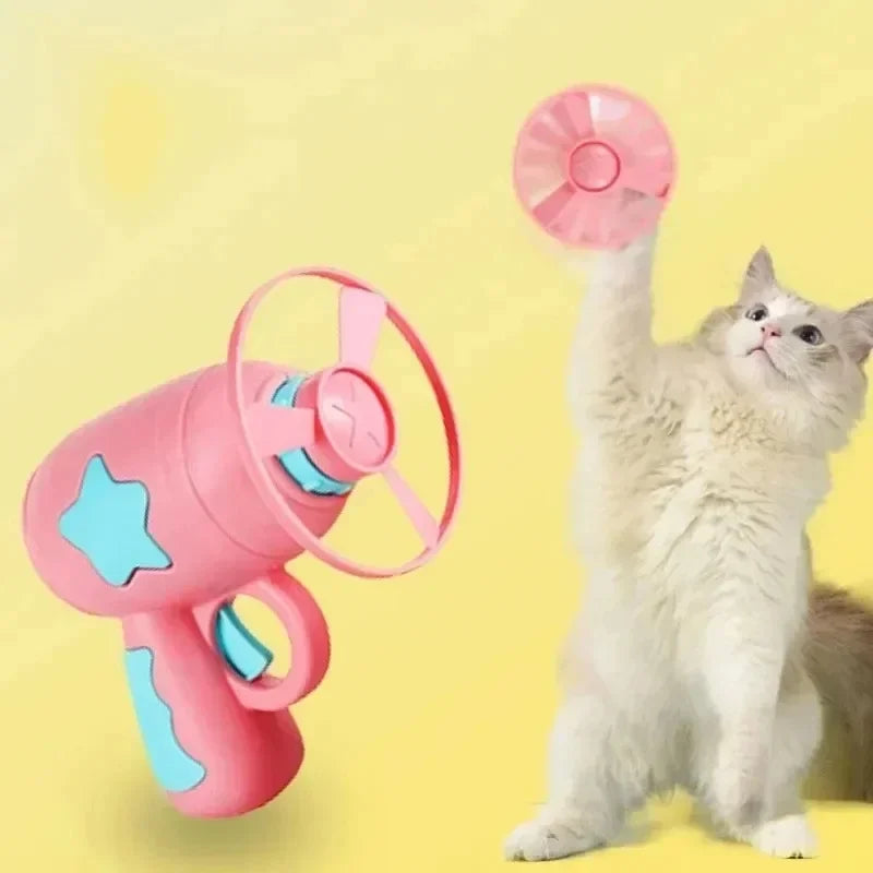 Un chat blanc duveteux interagit avec jouet volant rose interactif.