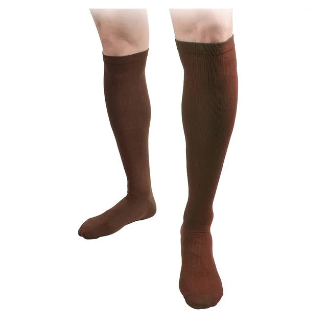 A pair of brown compression socks worn on a person's lower leg.