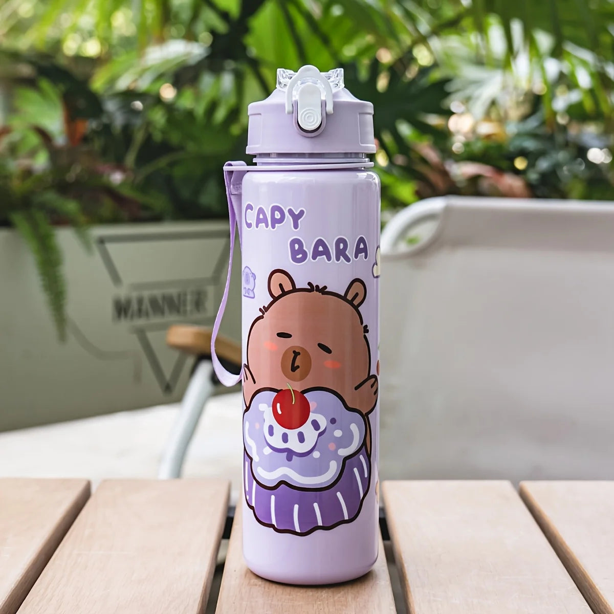 A purple cartoon drinking water bottle with a bear design and a clear straw, sitting on a wooden surface.