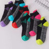Ein Set von sechs farbenfrohen, feuchtigkeitsableitenden Sportsocken mit verschiedenen Mustern und leuchtenden Farben.
