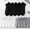 Eine Sammlung von schwarz-grauen Knöchelsocken auf einer weißen Oberfläche.