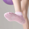 Close-up of a person's leg wearing pink non-slip grip socks with white dots.
