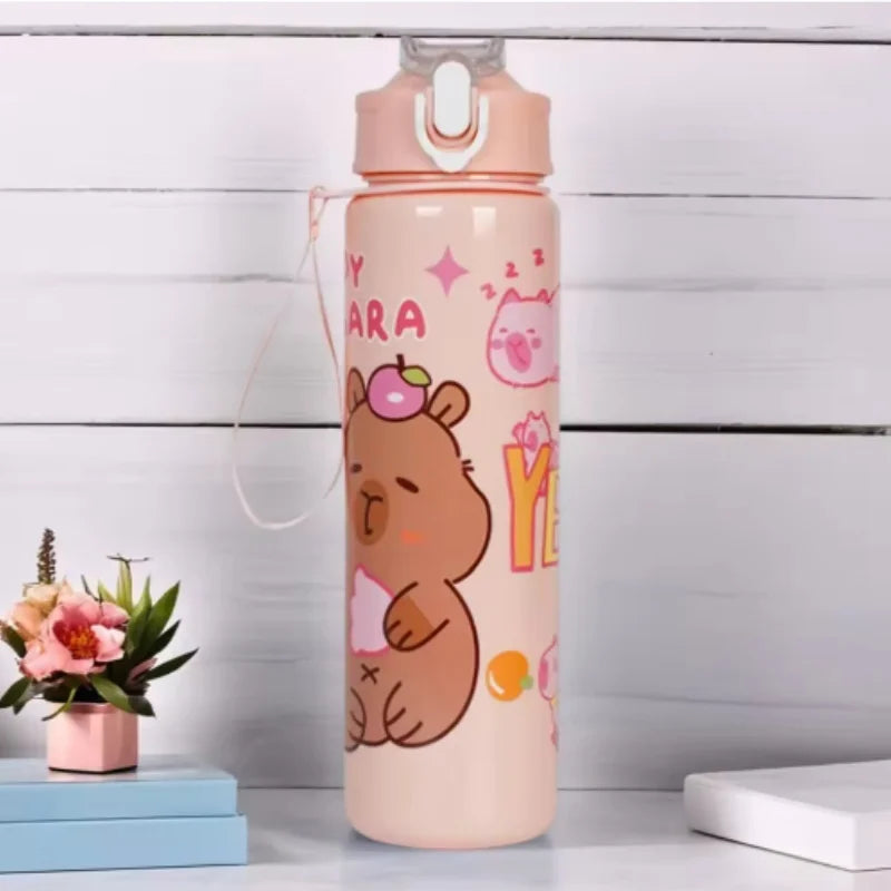 A pink water bottle shaped like a capybara with a straw and handle, standing on a white surface.