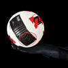A close-up of high-performance goalkeeper gloves with black and red accents shown on a hand.