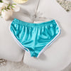 Türkis-Satin-Trainingsshorts mit Blumenakzenten auf weißem Untergrund.