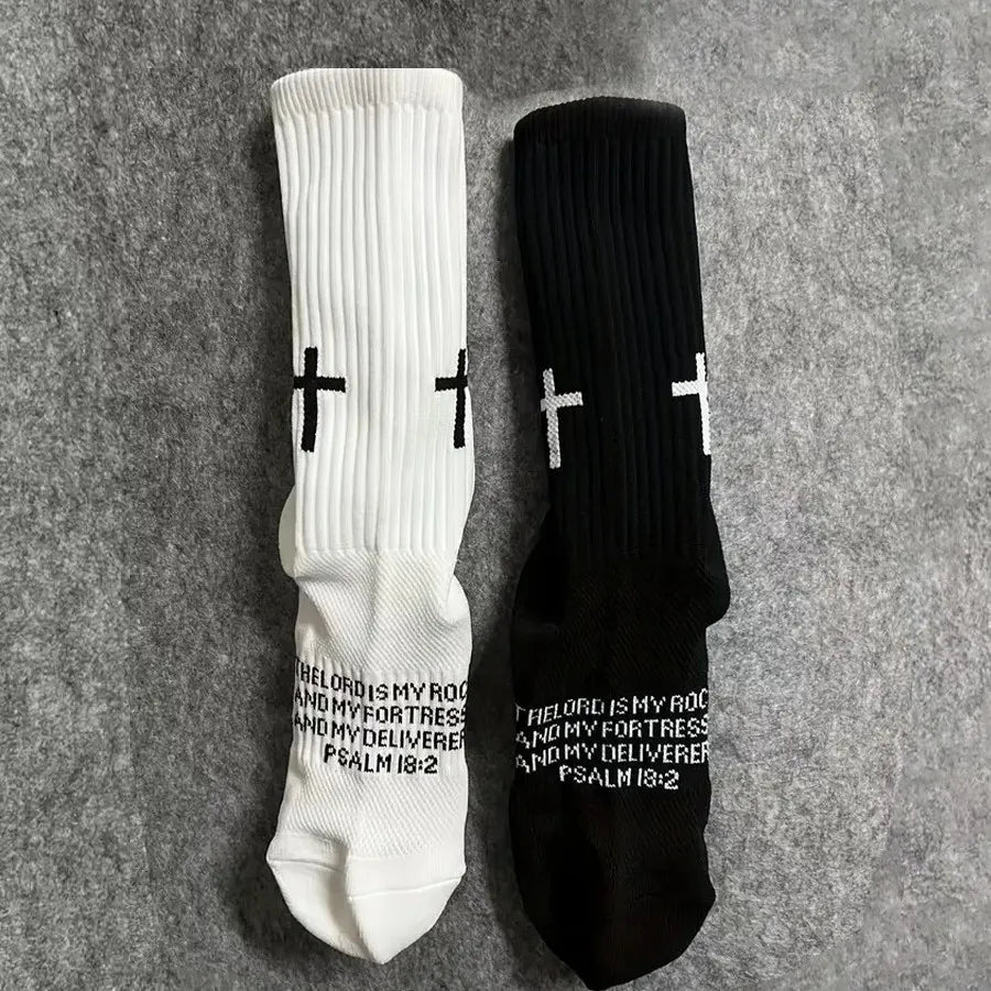 Pair of white and black cross printed athletic socks displayed on a gray background.