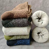A stack of three brown, black, and beige merino wool hiking socks