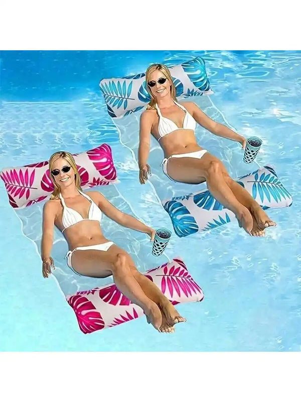 A smiling woman wearing a white bikini is relaxing on an inflatable pool float hammock in clear blue water.