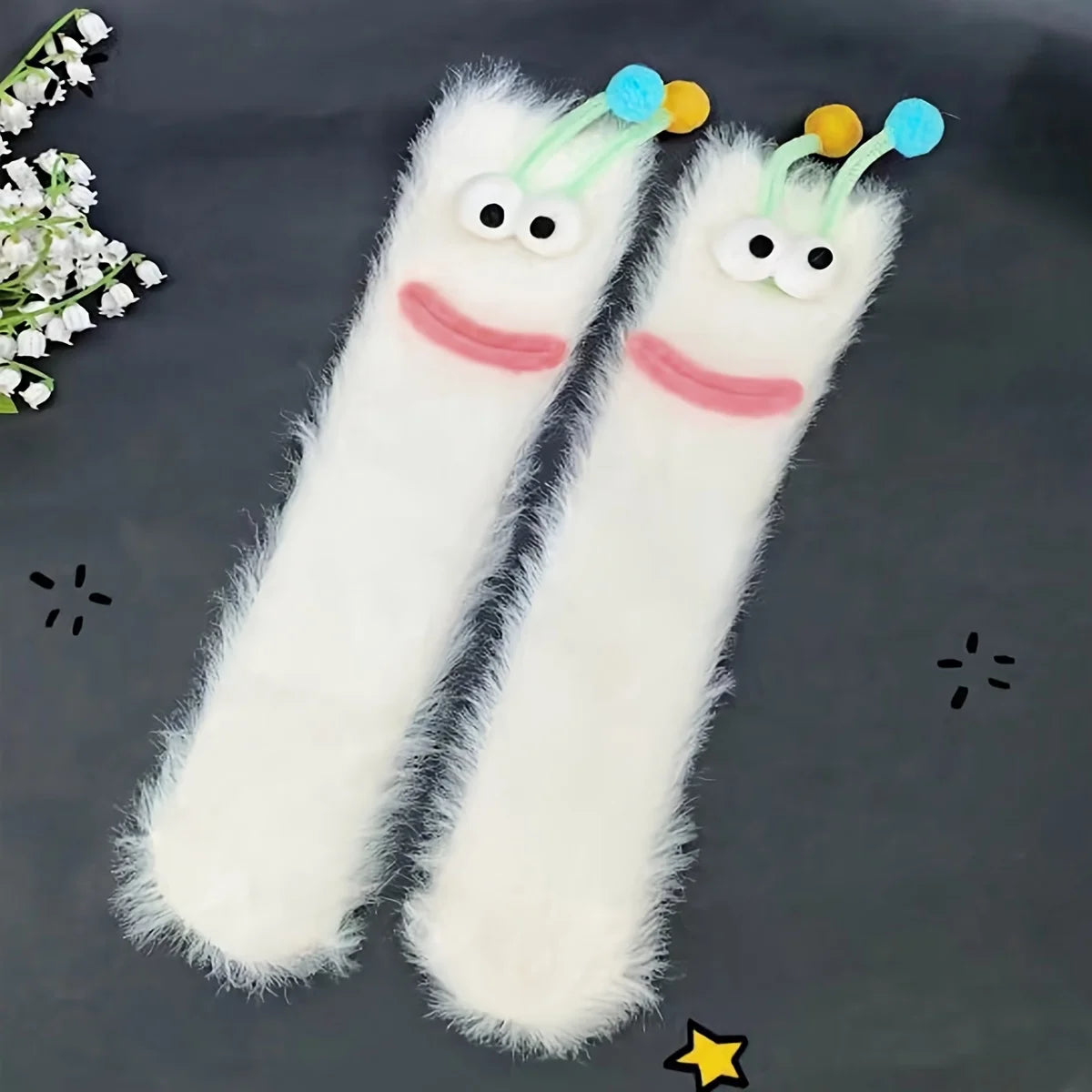 Pair of white plush caterpillar floor socks with blue accents