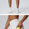 Eine Frau modelliert weiße, schnelltrocknende Sportshorts mit einer Tasche und einem limettengrünen Tennisball.