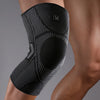 A black compression knee support sleeve worn on a person's leg.