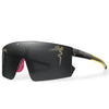 Black cycling sunglasses with gold detailing and a purple-tipped arm.