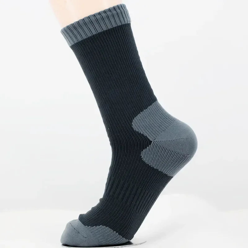 A close-up of dark gray waterproof breathable hiking socks worn on a foot.