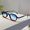 Black vintage oval sunglasses with blue and pink gradient lenses resting on a white surface.