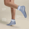 A close-up of light blue non-slip grip socks being worn on a leg, highlighting features like silicone grip and double-loop mo