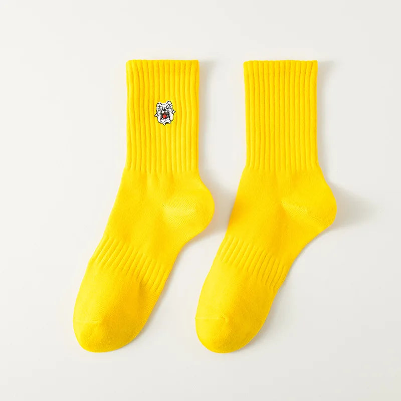 A pair of bright yellow men's athletic crew socks with an embroidered logo on the toe.