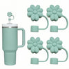 A teal silicone straw cover and tumbler set with multiple flower-shaped silicone covers.