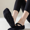 Black non-slip yoga and gym socks with silicone grip worn by a person.