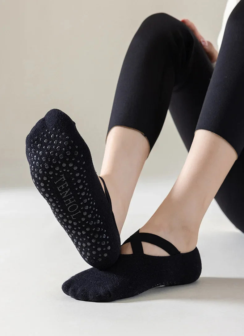 Black non-slip yoga and gym socks with silicone grip worn by a person.