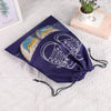A purple reusable non-woven shoe storage bag with white laces and a pair of shoes inside, resting on a white textured surface