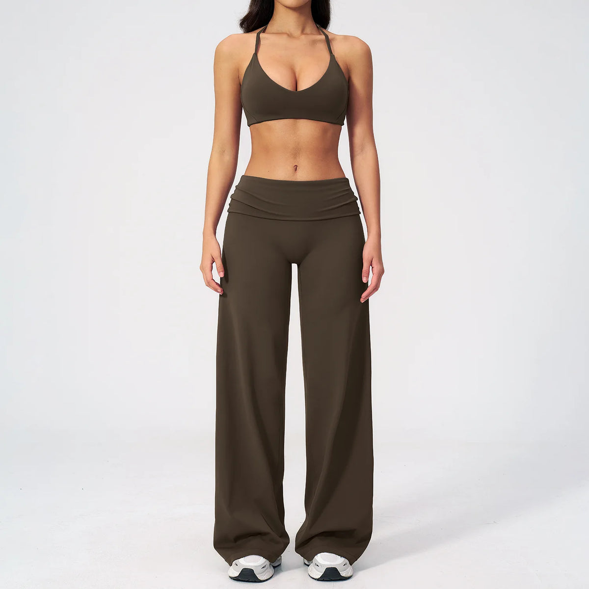 A woman wearing a brown women's premium fitness tracksuit top and matching pants.