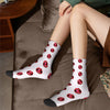 Mid-calf socks with a retro red lip print pattern worn by a person sitting on a brown couch.