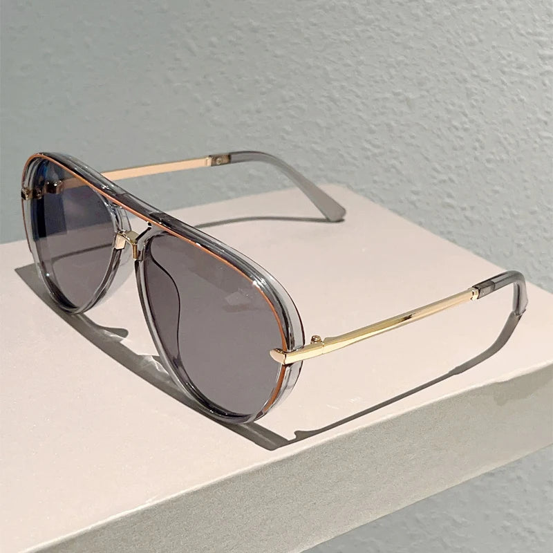 Vintage pilot gradient sunglasses with gold-toned arms resting on a light surface.