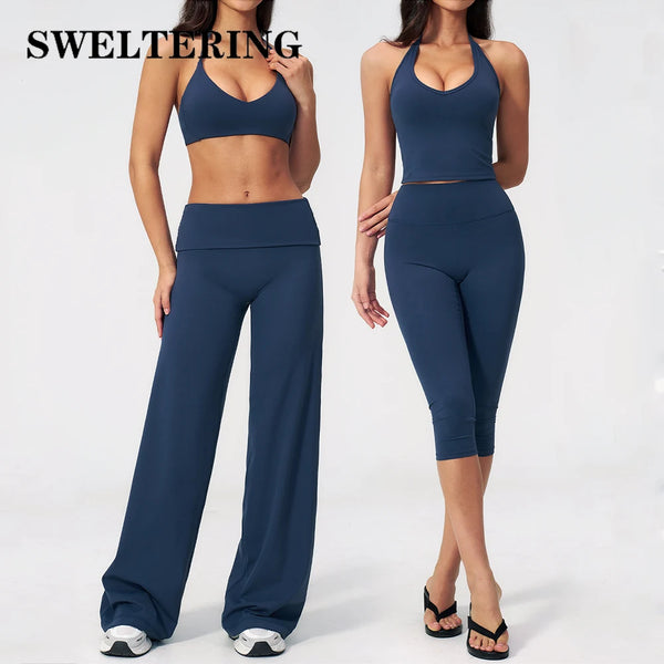 A woman models a navy blue women's premium fitness tracksuit consisting of a sports bra top and matching full-length leggings