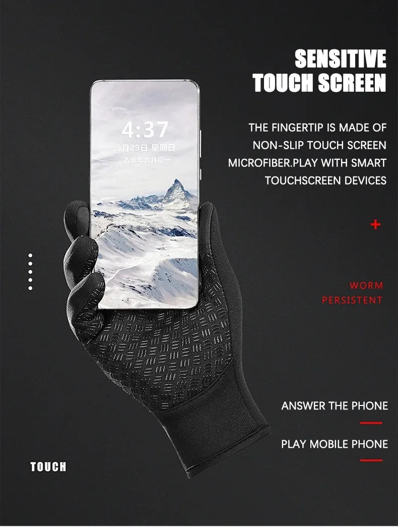 A hand wearing black touchscreen gloves is holding a smartphone displaying a mountain landscape.