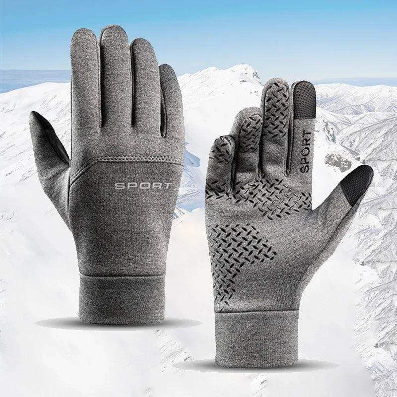 A pair of gray sports windproof winter gloves shown against a snowy mountain background.