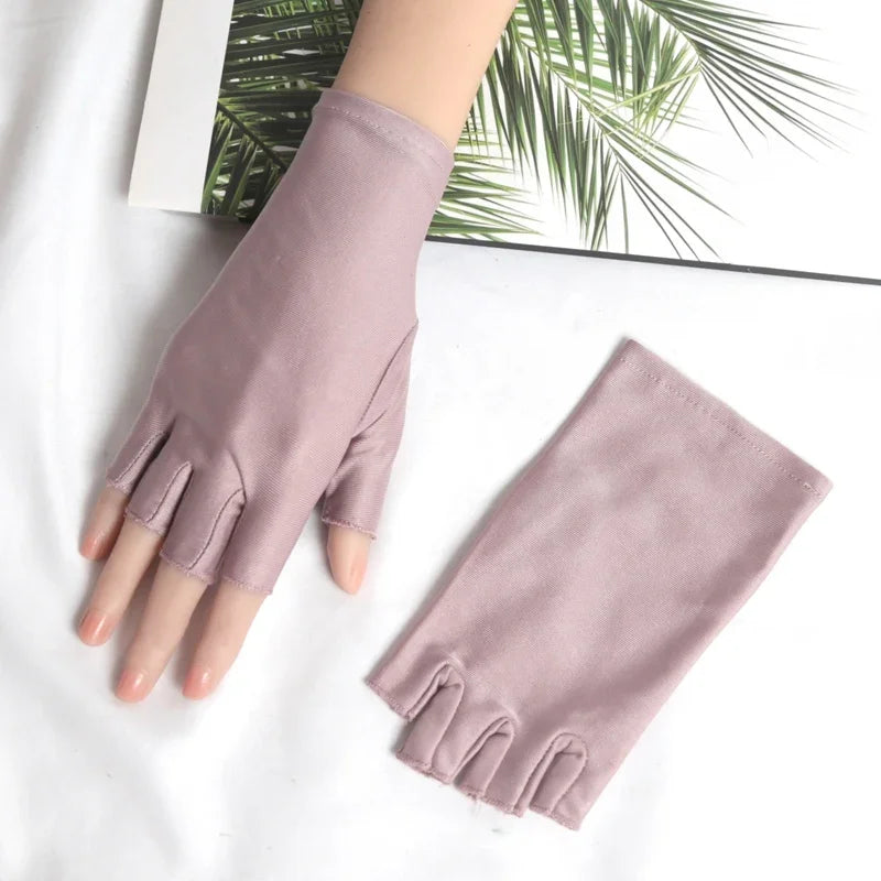 A pair of mauve women's thin stretch elastane gloves displayed on a white surface.