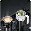 A black insulated stainless steel tumbler filled with iced coffee sits on a black mesh surface.