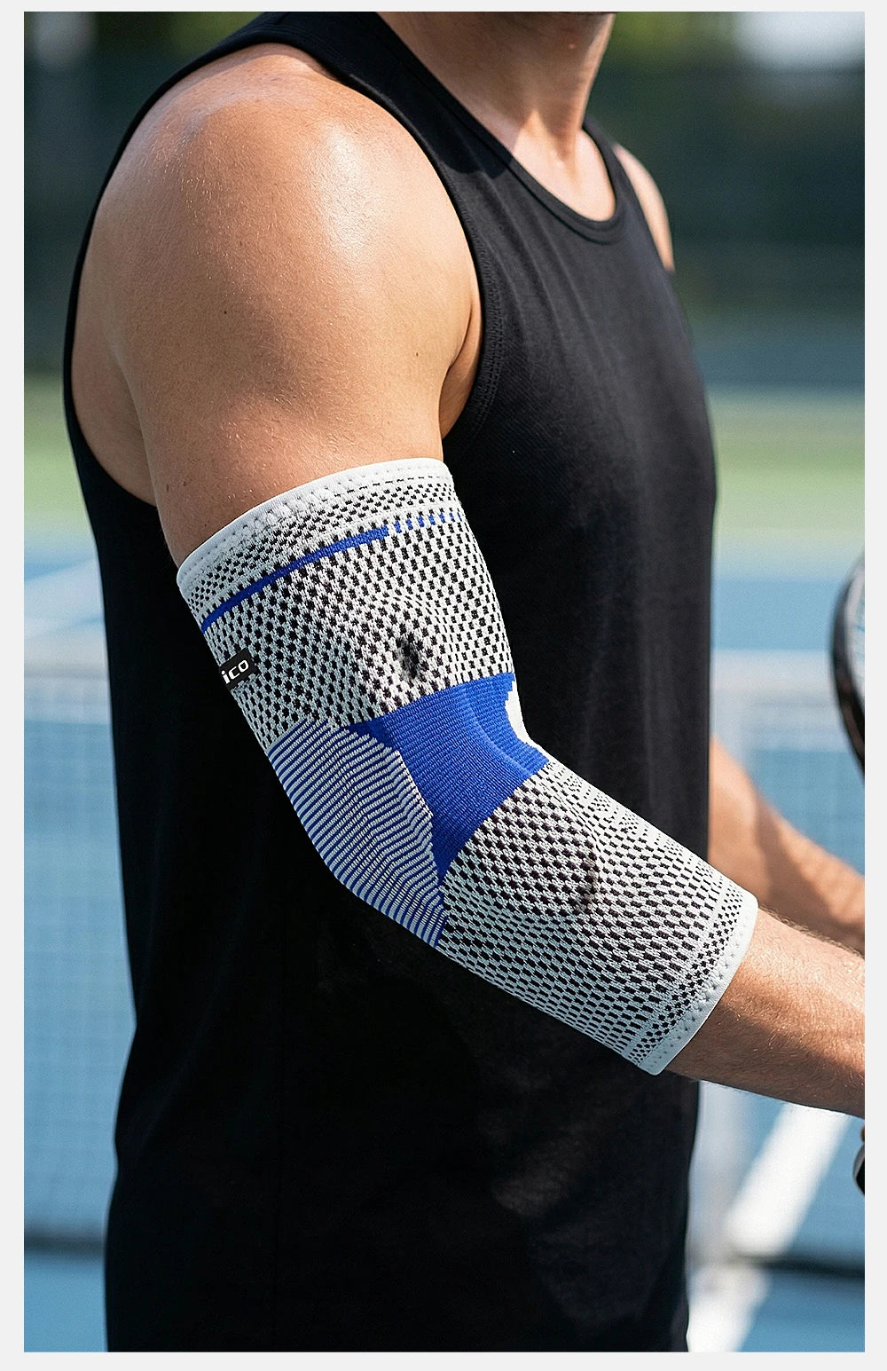A person wearing a white and blue silicone elbow guard sleeve on their forearm.