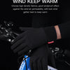 Black windproof sports gloves being worn on a bicycle handlebar.