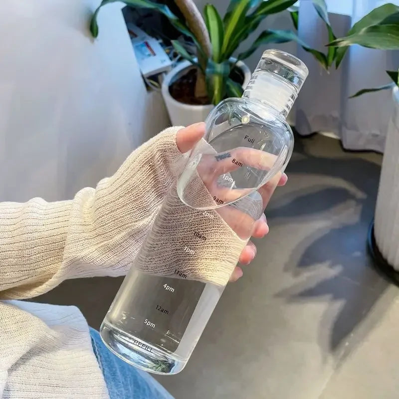 A hand holds a clear insulated water bottle with a time scale markings, demonstrating its leakproof design.