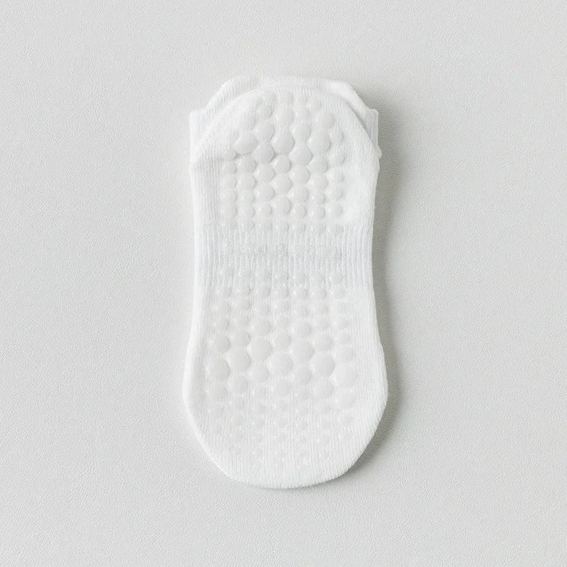 Une paire de chaussettes de yoga et de fitness blanches respirantes avec une semelle texturée.