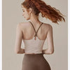 A woman with reddish hair wearing a beige supportive sports bra and matching bottoms, shown from the back.