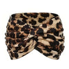 A close-up of a patterned brown and black leopard print fabric tied into a twisted fabric headband.