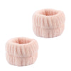 A pair of pink microfiber spa headband and wristband set with a fuzzy texture.
