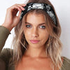 Une femme portant un bandeau de cheveux en coton extensible et bohème à motifs noir et blanc.