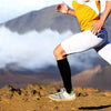 A woman wearing white athletic leggings and a yellow top is running outdoors on a rocky terrain.